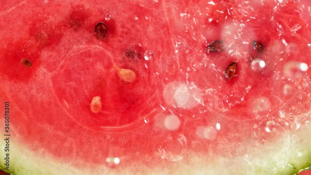 Super Slow Motion Macro Shot of Falling and Splashing Water Drops on Fresh Watermelon at 1000fps. Super Slow Motion Macro Shot of Falling and Splashing Water Drops on Fresh Watermelon at 1000fps.