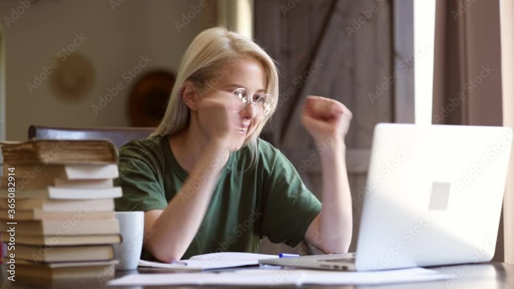 Blonde girl in glasses working with notebook at home as freelancer Blonde girl in glasses working with notebook at home as freelancer