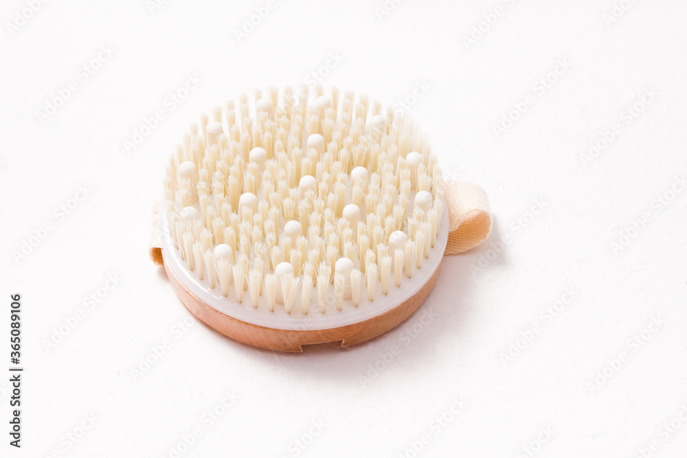 round wooden brush with natural bristles for dry anti-cellulite massage on a white background round wooden brush with natural bristles for dry anti-cellulite massage on a white background
