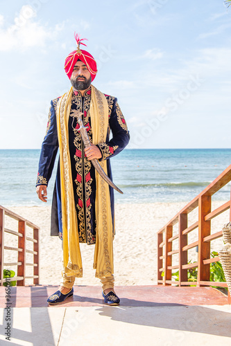 Sikh male model in traditional wedding attire preparing for ceremony