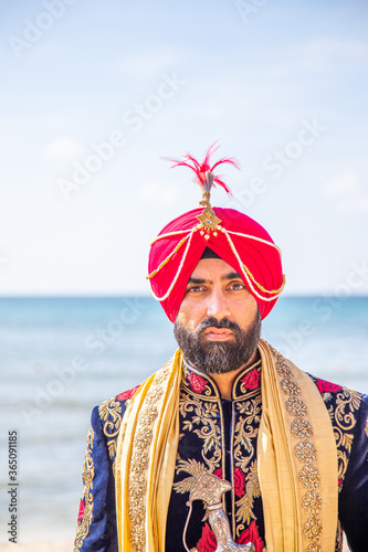 Sikh male model in traditional wedding attire preparing for ceremony