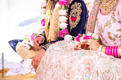 Sikh bride and groom next to each other during marriage ceremony in traditional wedding attire