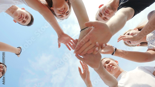 Friendly friends clasp hands as a sign of strong friendship and teamwork.