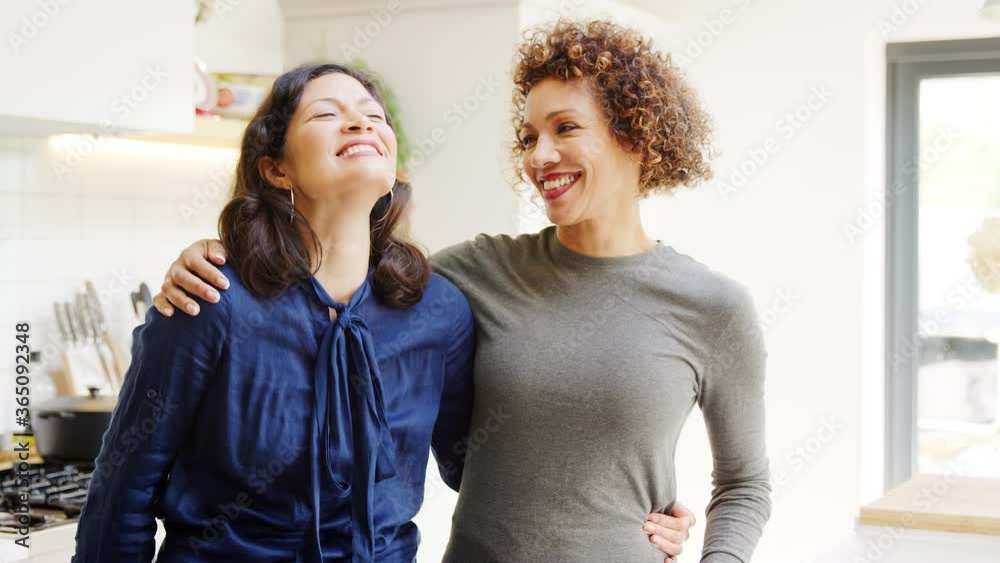 Portrait of loving gay mature female couple hugging in kitchen at home together - shot in slow motion Portrait of loving gay mature female couple hugging in kitchen at home together - shot in slow motion