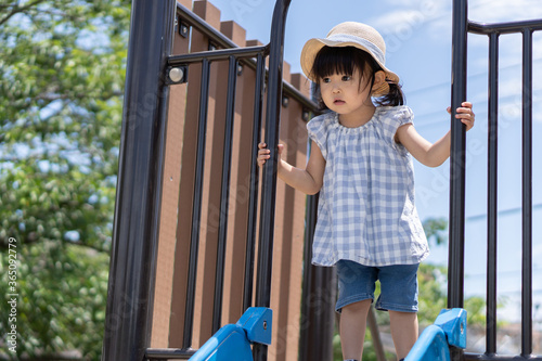 夏休みに公園の滑り台で遊ぶ子供