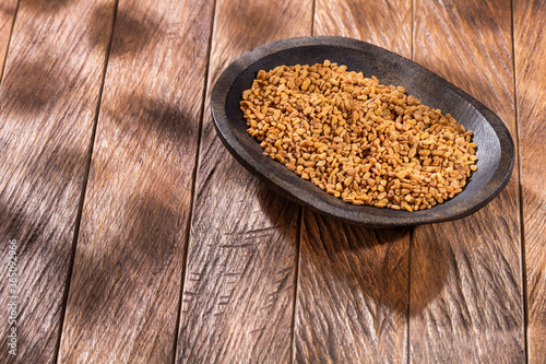 Fenugreek organic seeds in the wooden bowl - Trigonella foenum-graecum