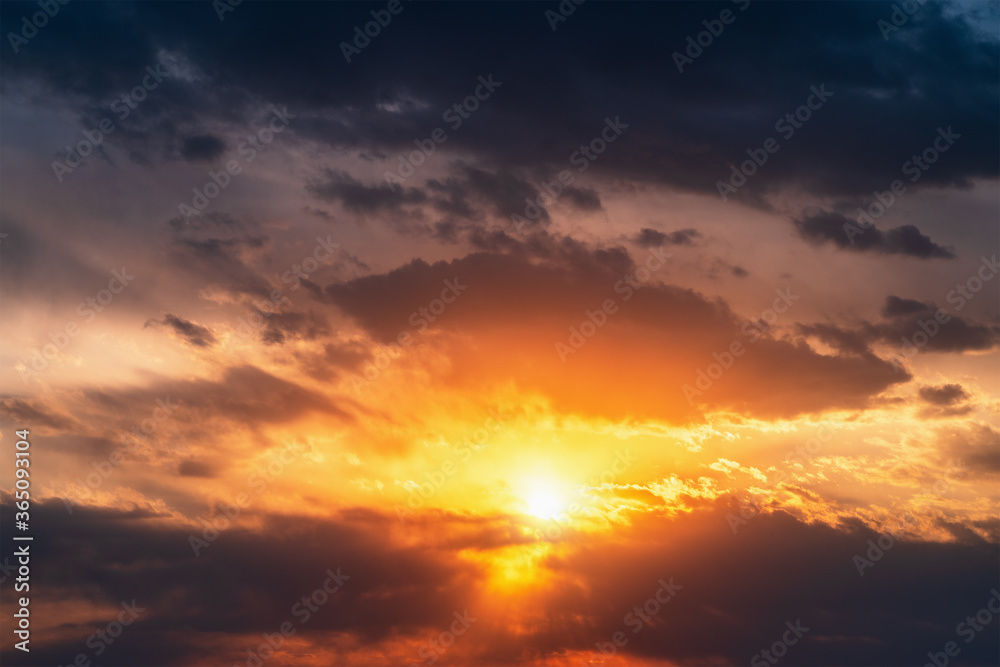 Bright dramatic sunset sky background. Beautiful colorful cloudscape with sun light.