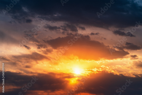 Bright dramatic sunset sky background. Beautiful colorful cloudscape with sun light. © DedMityay