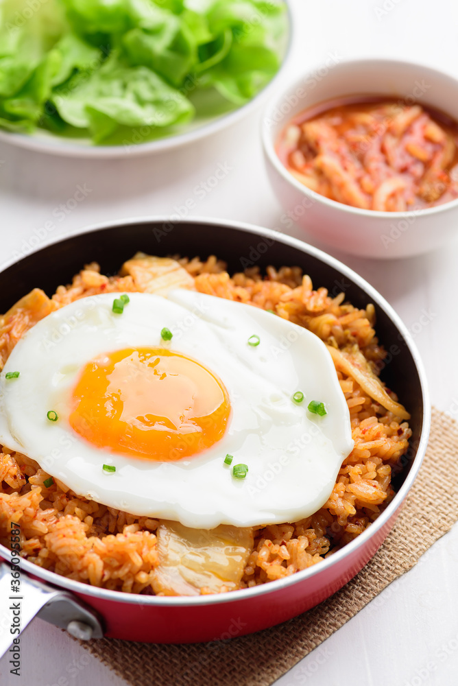 Kimchi fried rice with fried egg on top in small cooking pan, Korean food Kimchi fried rice with fried egg on top in small cooking pan, Korean food