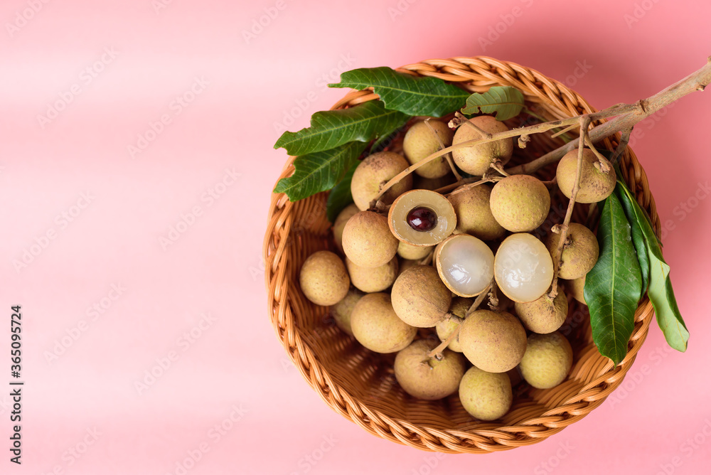 Fresh longan fruit in a basket on pink background, Tropical fruit