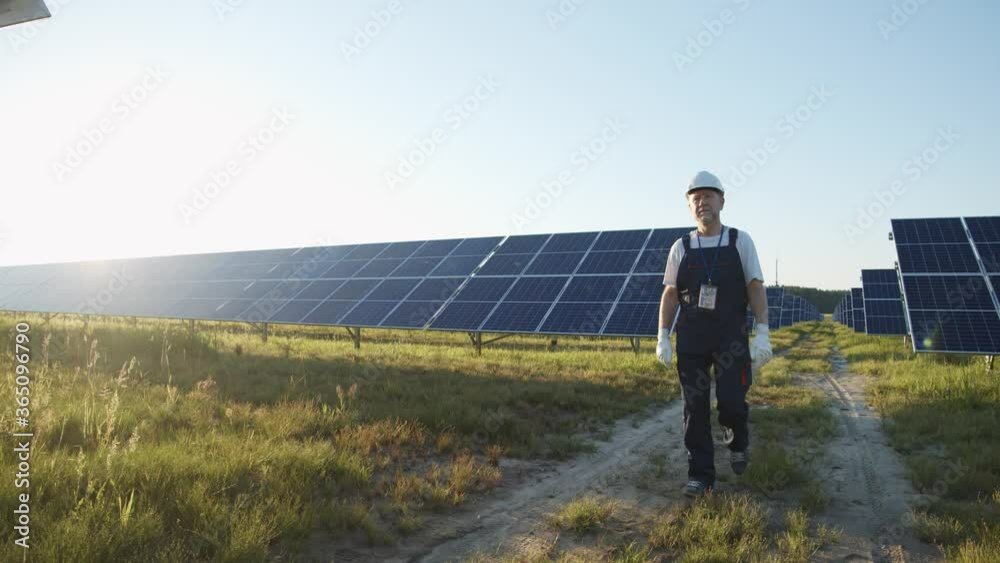 Chief caucasian engineer working on eco-friendly solar panel installation. Solar farm. Alternative energy sources. Ecological production of electricity. Chief caucasian engineer working on eco-friendly solar panel installation. Solar farm. Alternative energy sources. Ecological production of electricity.