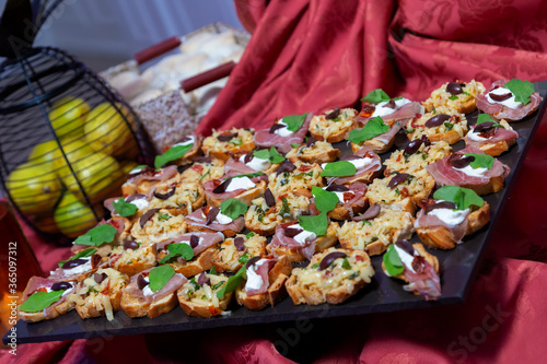 canapes of ham, cheese, cream, tomatoes on toasts on frua buffet table photo