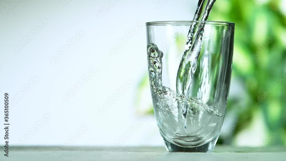 Super slow motion of pouring water from bottle into glass. Filmed at 1000 fps.