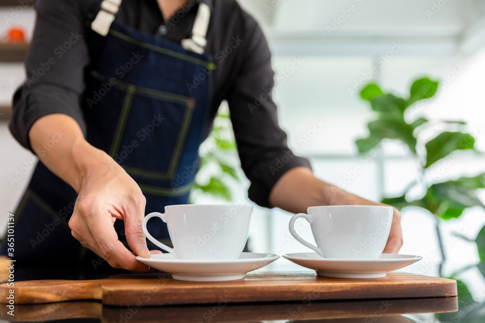 Barista pouring black coffee to white cup for service in coffee shop. - obrazy, fototapety, plakaty 