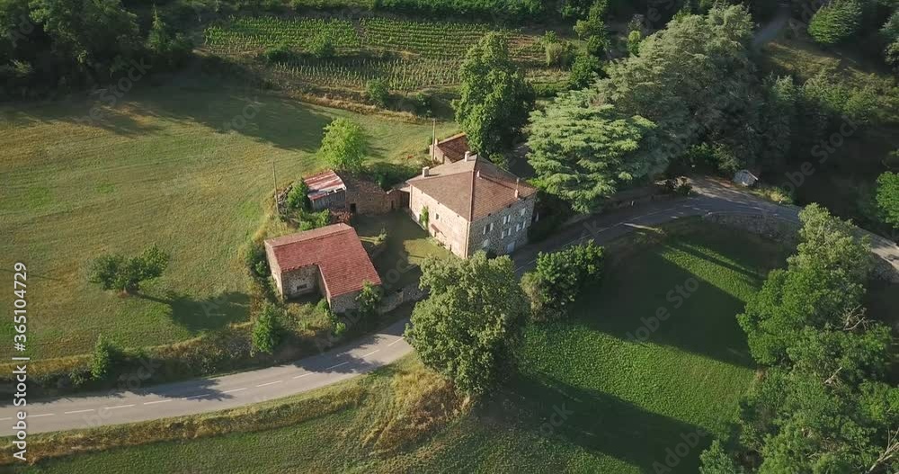 Dolly aerial shot around an isolated stone farmhouse in a rural background Dolly aerial shot around an isolated stone farmhouse in a rural background