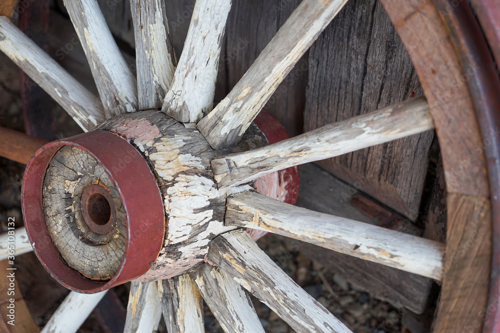 Old weathered wooden wagon wheel with flaky white paint. Old weathered wooden wagon wheel with flaky white paint.