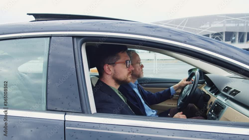 Caucasian pensioner drives car with instructor to pass driving license examination. Driving lesson. Couple of multi-age bearded men in the car. Caucasian pensioner drives car with instructor to pass driving license examination. Driving lesson. Couple of multi-age bearded men in the car.