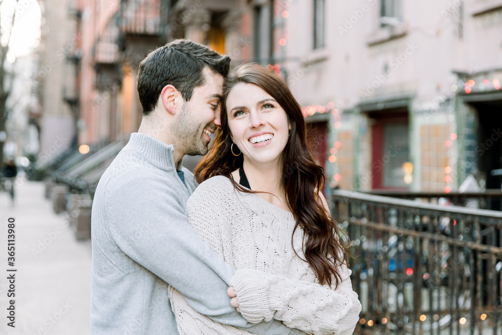 A couple keeping each other warm in the city