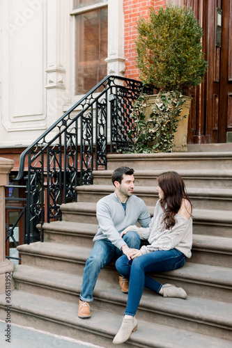 A young couple sitting on a stoop and casually chatting