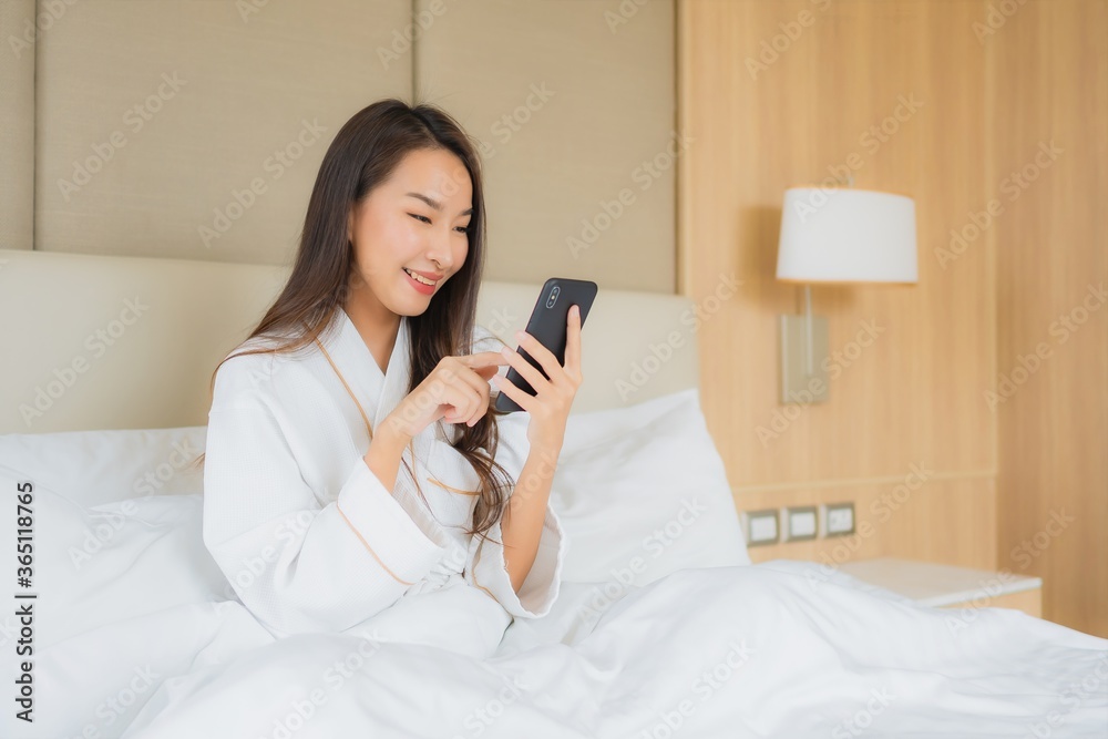 Portrait beautiful young asian woman with smart mobile phone in bedroom Portrait beautiful young asian woman with smart mobile phone in bedroom