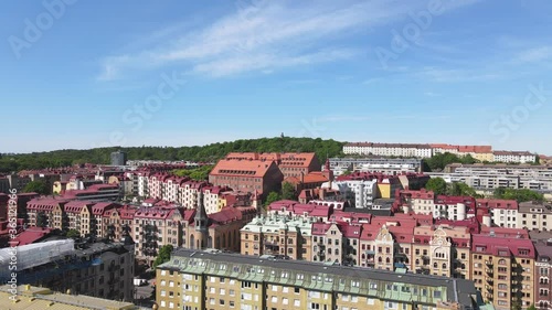 Drone shot above Landscape of Gothenburg. Aerial view of beautiful apartment buildings with red roofs of Vastra Gotaland, Sweden. Colorful day scene with blue sky view green trees and bushes around. photo