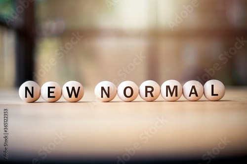 new normal,word on wooden circle, affectation after covid-19 pandemic