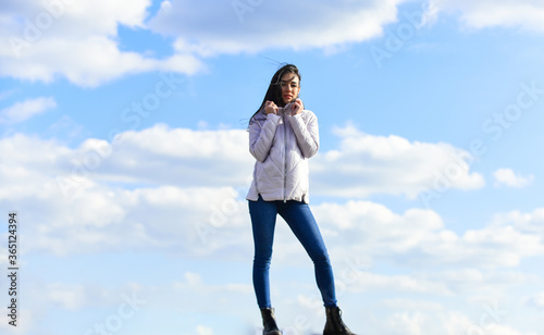 girl wear jacket in city street. Stylish fashion model outdoor. People freedom style. Winter Warm Clothing. girl wearing casual jeans clothes. enjoys sunny day and blue sky. beauty and fashion