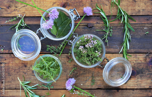 top view on aromatic herbs in glass jar on wooden rustic table