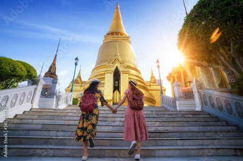 Two asian girlfriends traveling and check location by a map in Grand Palace and Wat phra kaew Bangkok city,Thailand