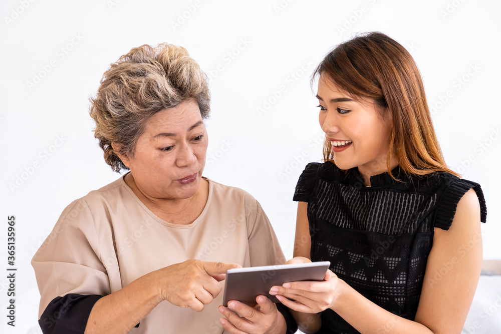 Happy senior elderly Asian woman female mother and daughter enjoy online shopping using digital tablet Happy senior elderly Asian woman female mother and daughter enjoy online shopping using digital tablet