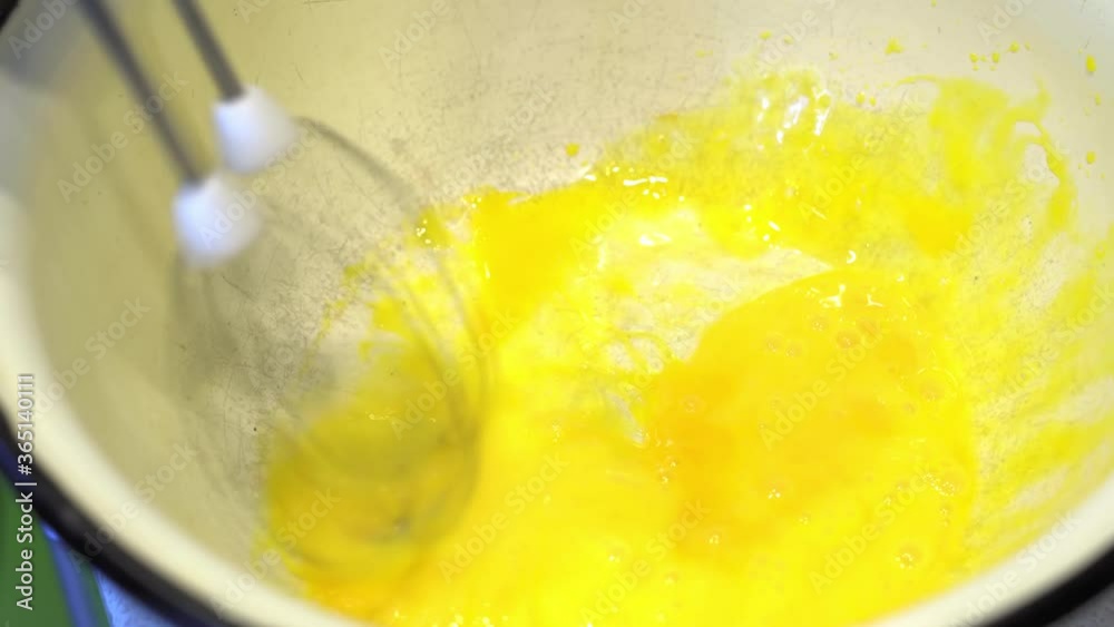 Whipping Eggs in a Bowl with an Electrical Hand Mixer. Food Blog. Footage food. Cooking food at home. Home atmosphere in the kitchen.