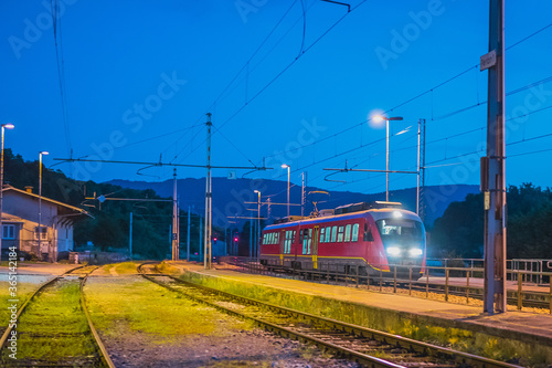 Passenger train stopping on a station of Preserje in Slovenia. during evening hours. Evening setting of an newer type of commuter train.