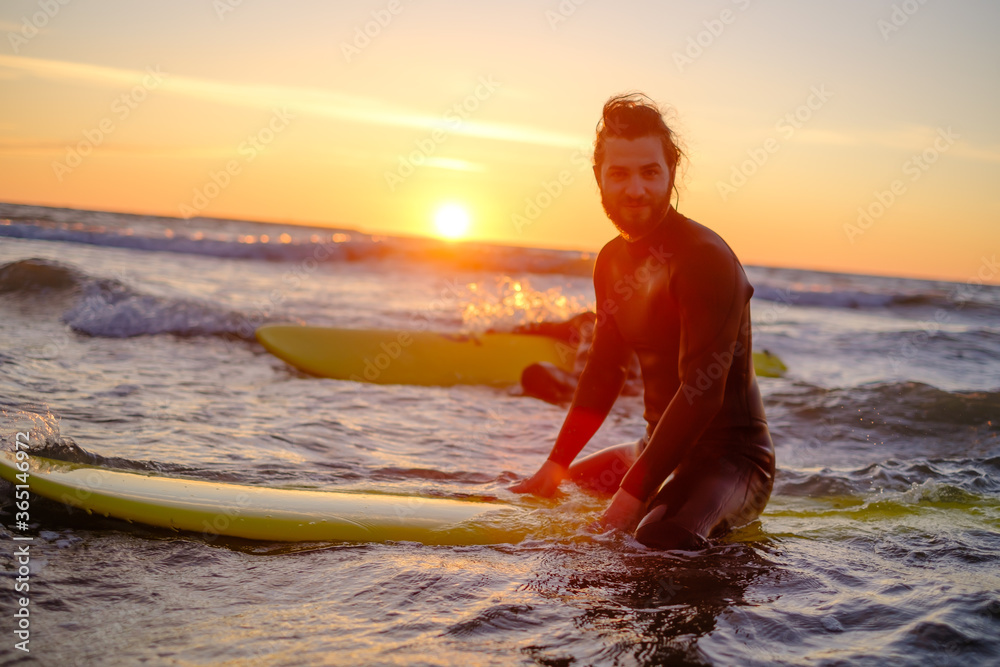 Surfer sitting on surfboard in sea