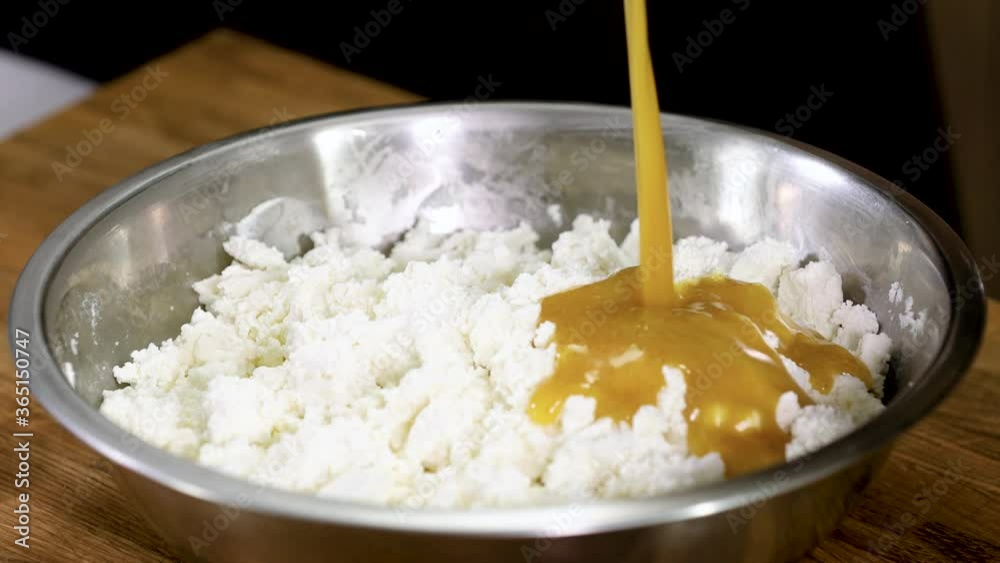 Chef pouring mixture of the egg yolks and butter into a bowl with curd cheese. 4K Chef pouring mixture of the egg yolks and butter into a bowl with curd cheese. 4K