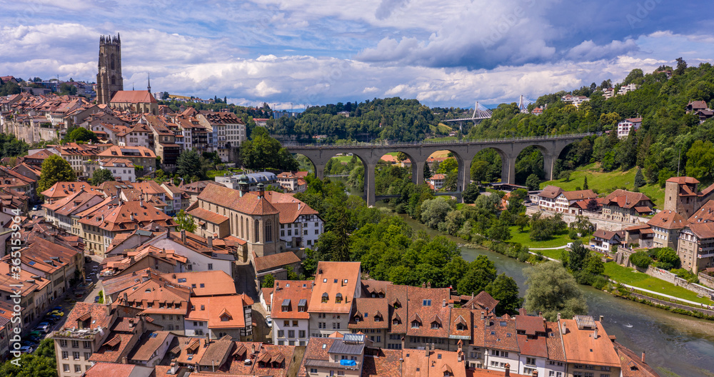 Aerial views of the rooftops, landmarks, river and bridges of the old town of Fribourg in Switzerland.