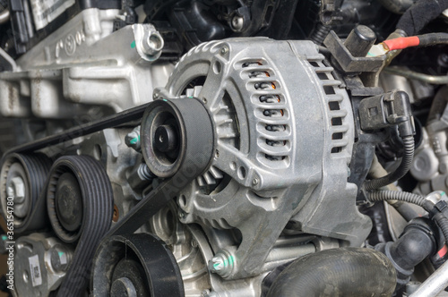 Close up of alternator with pulley on Diesel engine background, a generator that produces an alternating current for supply and charging battery in car.