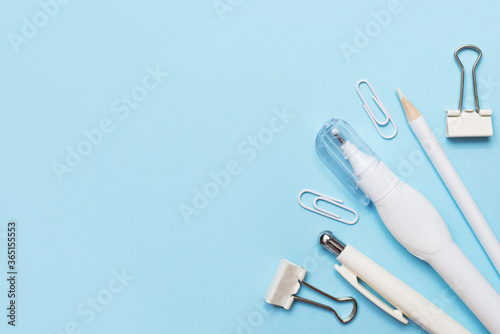 White and blue office supplies on blue background with a copy space
