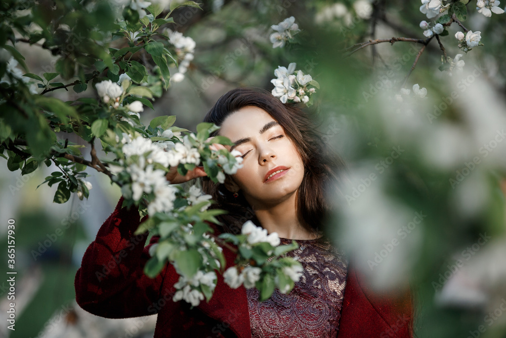 a girl in a flowery garden in a maroon coat a girl in a flowery garden in a maroon coat