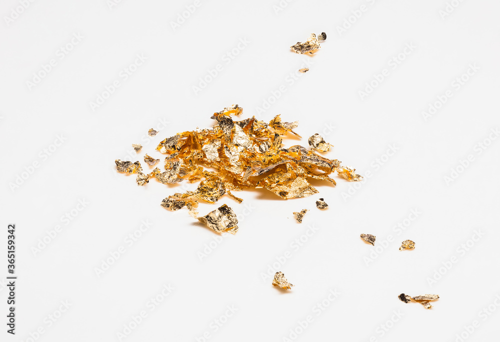 Shiny pieces of gold leaf, foil on a white background Shiny pieces of gold leaf, foil on a white background