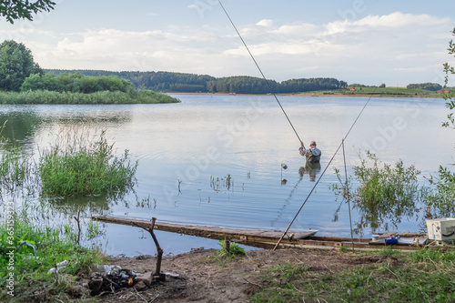 fisherman in the water with a fishing rod on the lake