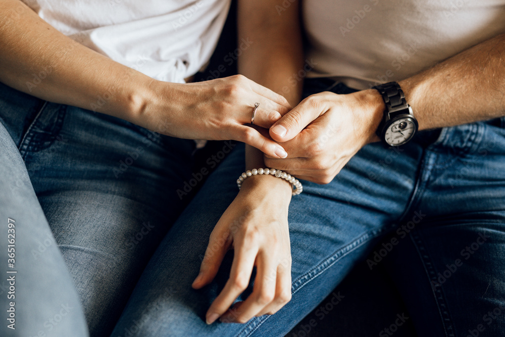 Romantic couple holding hands sitting on sofa