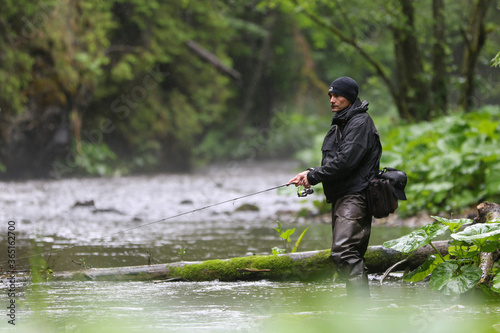 A fisherman walking for wild river and a breathtaking scene in the forest with colourful reflections on the river. Fishing day hunting for a trout. Finding solitude in the wilderness.