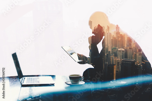 Foto Double exposure silhouette of man skilled managing director is analyzing activities of the company by using touch pad and net-book