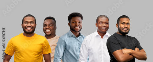 race, ethnicity and people concept - group of happy smiling young african american men over grey background