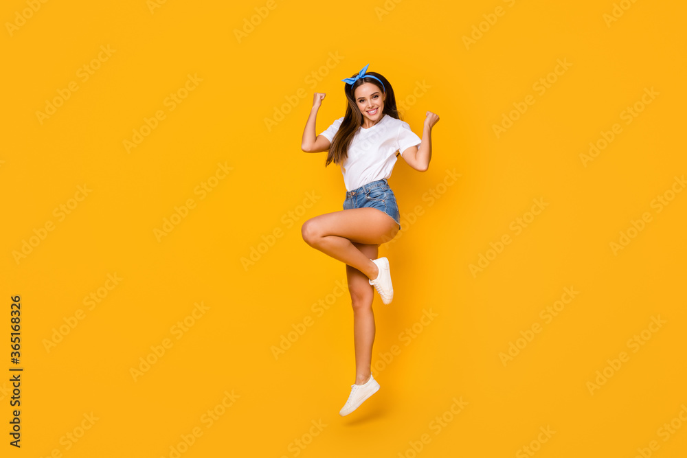 Full size photo of cheerful crazy girl win spring discount lottery jump raise fists wear good look lifestyle outfit shoes blue headband isolated over bright color background