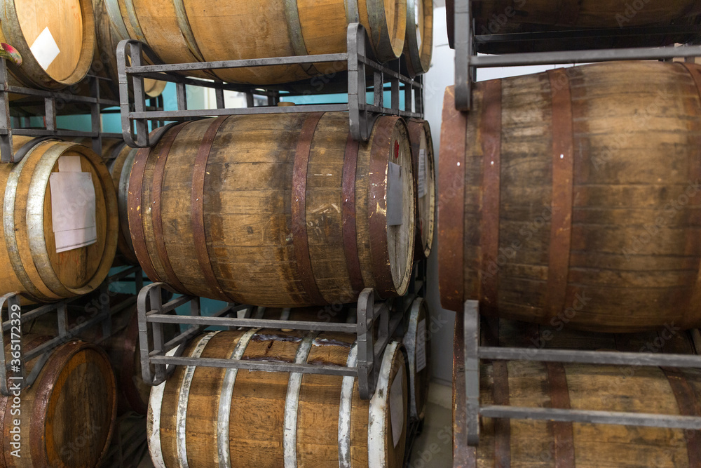 manufacture and production concept - wooden barrels at craft brewery or winery