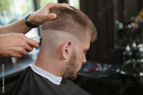 Rear view close up of a haircut in progress done by professional barber