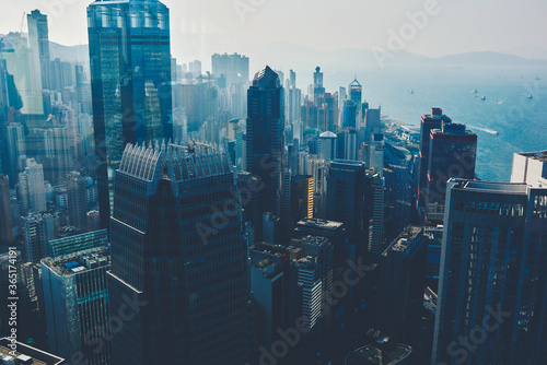 View from high on a business center with high skyscrapers and sea with floating yachts. Modern developed metropolitan city with office and commercial buildings with contemporary architecture