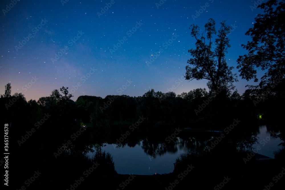 Stars shine bright over a lake at night