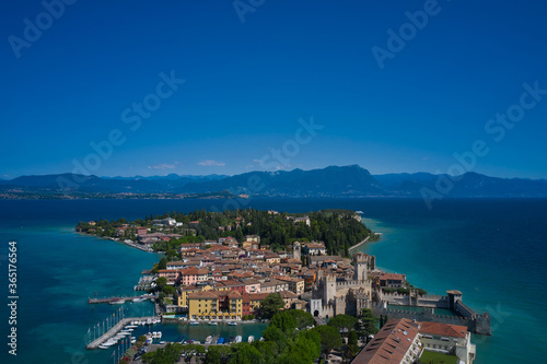Sirmione, Lake Garda, Italy. Panoramic aerial view of the historic city of Sirmione. In the background mountains, blue sky